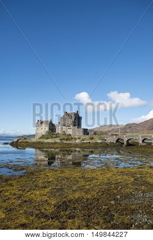 Popular tourist destination of Eilean Donan Castle Scotland beautiful 13th century fortification at Dornie Kyle of Lochalsh in the Scottish Highlands with clear blue sky and reflections