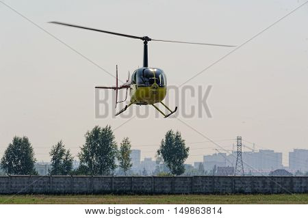 Tyumen, Russia - August 11, 2012: On a visit at UTair airshow in heliport Plehanovo. Pilot of Robinson R44 Raven shows flying opportunities