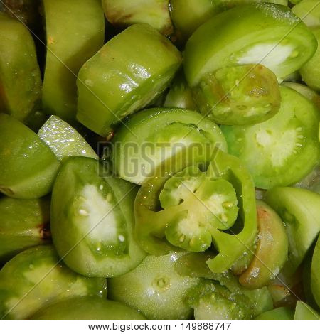 Heap of cut small green tomatoes background