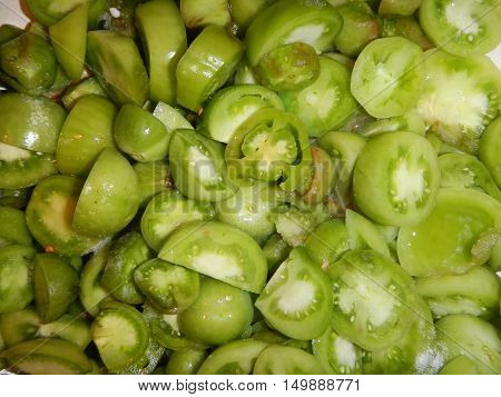 Heap of cut small green tomatoes background