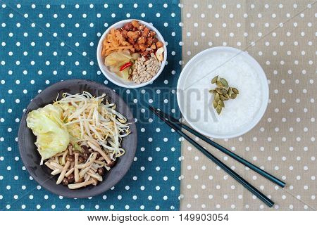 Chinese vegetable festival as rice gruel and fried mixed vegetable served side dish.  (topped roasted pumpkin kernel and mushroom, bean sprouts,cabbage served bean cabbage,sweet radish and pickle )