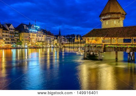 Night view towards Chapel Bridge (Kapellbruecke) together with the octagonal tall tower (Wasserturm) it is one of the Lucerne's most famous tourists attraction