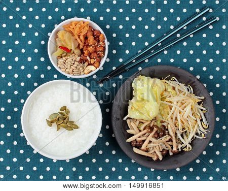 Chinese vegetable festival as rice gruel and fried mixed vegetable served side dish.  (topped roasted pumpkin kernel and mushroom, bean sprouts,cabbage served bean cabbage,sweet radish and pickle )