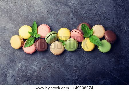 Colorful macaroons on stone table. Sweet macarons. Top view with copy space for your text