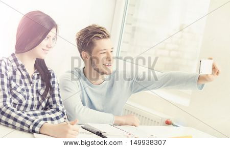 Boy and girl taking selfie on a lesson at chool.