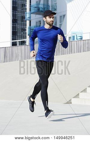 Running man in town wearing blue sportswear