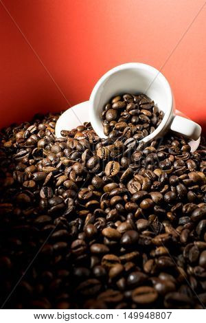 A coffee cup full of beans in a red background