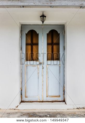 Old wooden door with White cement wall