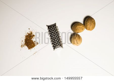 Nutmeg nut and powder in a white background