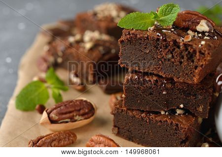 Delicious chocolate brownie with pecan nuts on a gray background