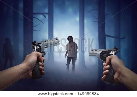 Man hand holding two gun and ready to shooting walking zombie to him