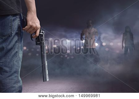 Brave Man With Jeans Pants Holding Gun Looking At Zombies