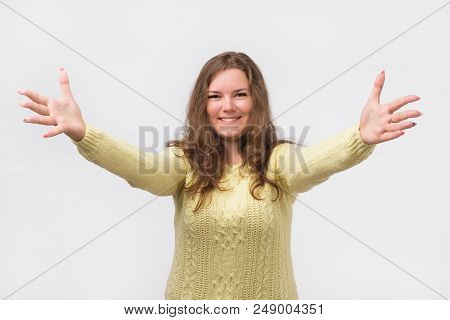 Portrait Of Attractive Smiling Caucasian Woman Raised Up Arms Hands At You. She Is Dressed In Yellow