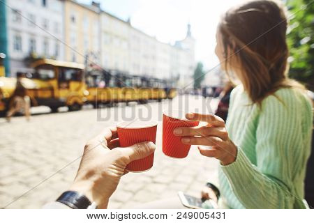 First Person View On A Woman In Green Sweater Drinking Coffee From Small Paper Cups With Boyfriend. 