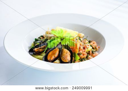 Fresh Seafood Salad With Prepapred Clams, Shrimp And Lemon In A White Plate On Gray Background