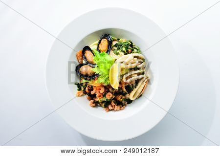 Fresh Seafood Salad With Prepapred Clams, Shrimp And Lemon In A White Plate Isolated On White Backgr
