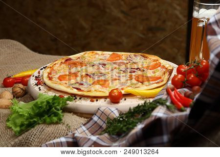 Pizza With Tomato, Cheese, Smoked Sausage, Boiled Sausage, Pepper Spices On A Wooden Tray, With Beer