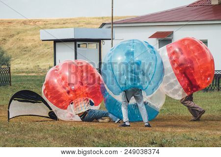 People Play Bumperball Zorbsoccer Outdoor. Summer Time