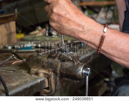 Threading Die Vised In Iron Grip By Worker's Hands, Close Up View. Working Process Of Thread Cutting