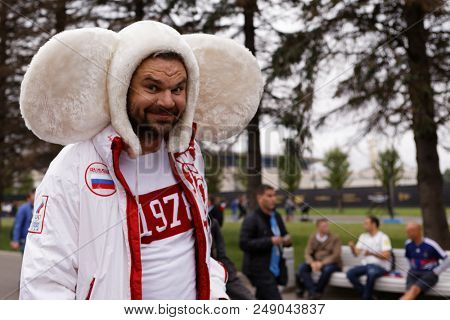 ST. PETERSBURG, RUSSIA - JULY 10, 2018: Russian football fan in the costume of cartoon character Cheburashka at Saint-Petersburg stadium before the semifinal match of FIFA World Cup Russia 2018