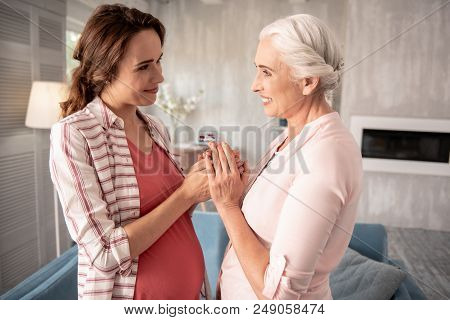 Feeling Emotional. Aged Woman Feeling Really Emotional And Passionate While Seeing Her Pregnant Daug