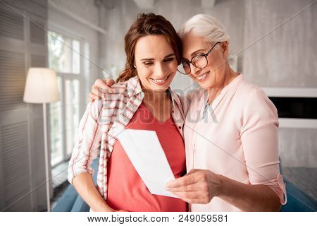 Providing Support. Woman Wearing Stylish Black Glasses Smiling Providing Support To Her Pregnant Dau