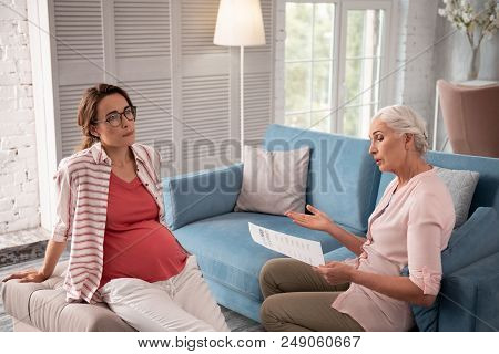 Private Psychologist. Pregnant Woman Wearing Glasses Feeling Attentive While Listening To Private Ps