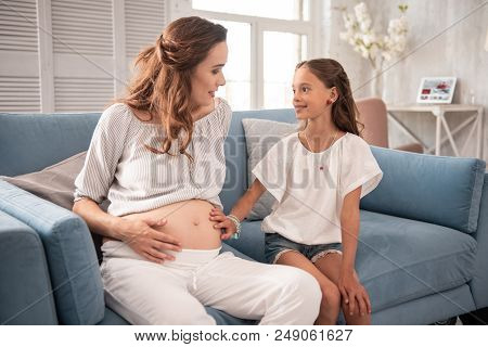 Cute Daughter. Little Cute Daughter With Nice Wavy Hair Feeling Excited While Coming To Her Pregnant