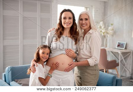 Photo Session. Three Women Of Different Generations Participating In Photo Session Wearing White Or 