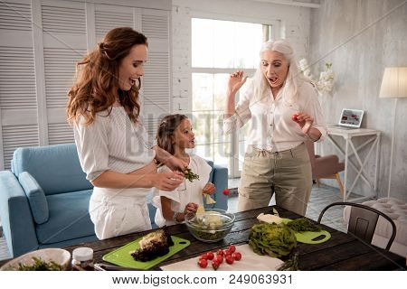 Cooking Together. Two Women Having Fun While Cooking Together With Little Cute Girl