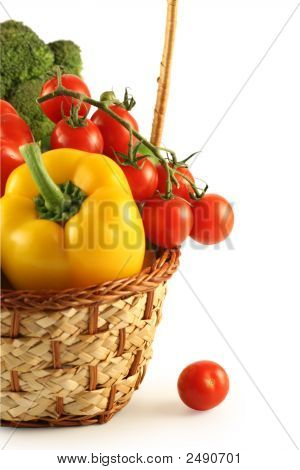 Brokolice, paprika a rajčata v košíku na bílém pozadí.