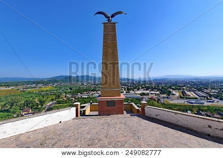 A Commemorative Sign In The Form Of A High Stone Pillar With An Eagle Standing At The Top With Outst