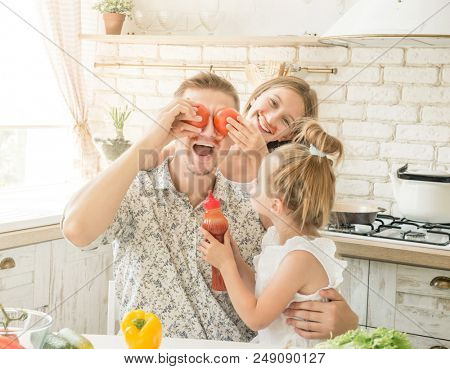 dad with two little daughters have a fun in the kitchen