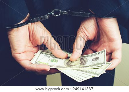 Arrested Official In Handcuffs Counting Dollar Banknotes. Concept Of Fraud, Detention, Crime And Bri