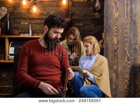 Man With Trendy Hipster Beard Whetting Knife Blade With Old Leather Belt. Bearded Man Sharpening Raz