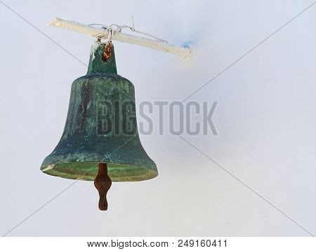 Old Greek Metal Church Bell On White Wall.