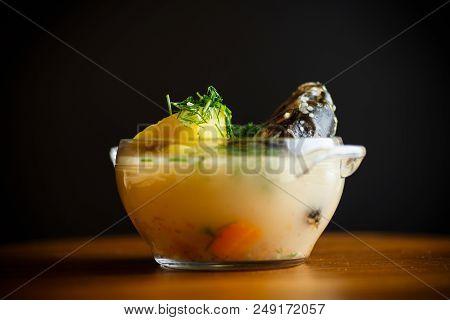 Vegetable Soup With Fish In A Glass Bowl On A Wooden Table