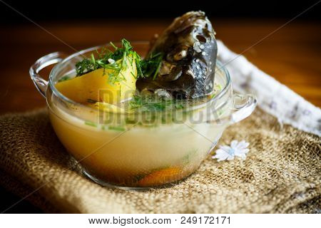 Vegetable Soup With Fish In A Glass Bowl On A Wooden Table
