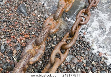 Two Old Rusty Shipping Chains On The Seashore