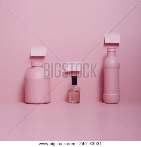 Three Bottles And Three Stickers On The Pink Table