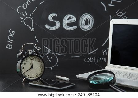 Seo Search Engine Optimization Concept Magnifying Glass, Clock, Smartphone On A Black Background Wit