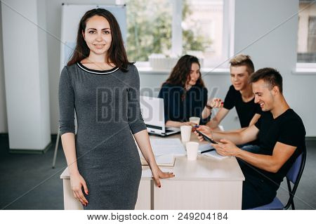 Young Successful Business Woman Portrait With Colleagues Meeting Behind Her. Friendly Atmosphere, Co