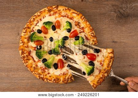 Hand Taking A Piece Of Delicious Pizza With Stretchy Mozzarella, View From Above