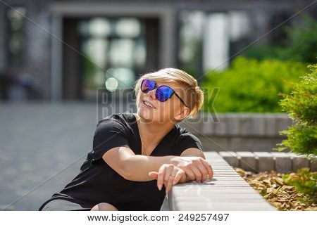 The Girl Plus The Size In Sunglasses Smiles, Joyful, Happy On A Bright Sunny Day In The Street, A Ha