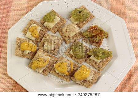 Baked Whole Wheat Crackers Topped With Cheddar Cheese, Guacamole, Horseradish, Mustard And Hot Sauce