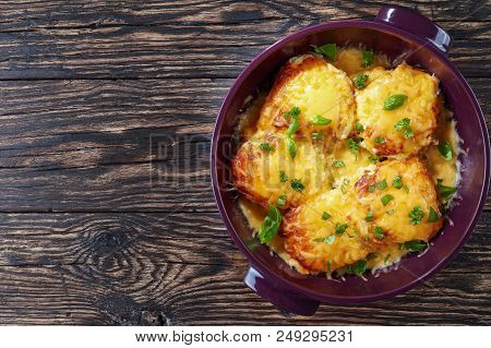Pork Chops Topped With Onions, Mayo And Cheese In A Baking Dish On A Old Dark Wooden Table, View Fro
