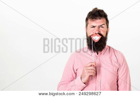 Emotional Dissonance Concept. Man Holding Party Props Smiling Lips While His Face Serious, White Bac