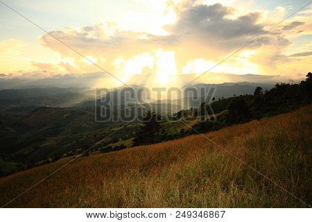 Dramatic God Lights Passing Through Clouds And Shining On Mountain Ranges. Warm Light Shower. God Ho