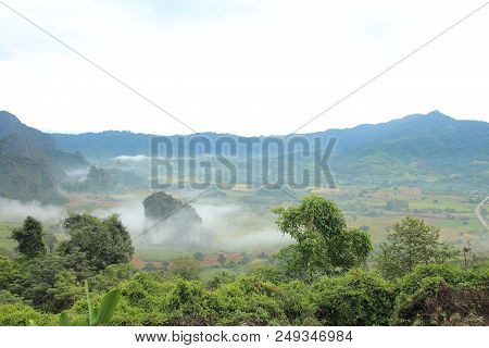 Rock Mountain Protruding From Rice Field. Morning Fog On Sunrise In The Phulanka, Phayao Thailand.