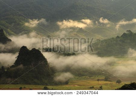 Rock Mountain Protruding From Rice Field. Morning Fog On Sunrise In The Phulanka, Phayao Thailand.